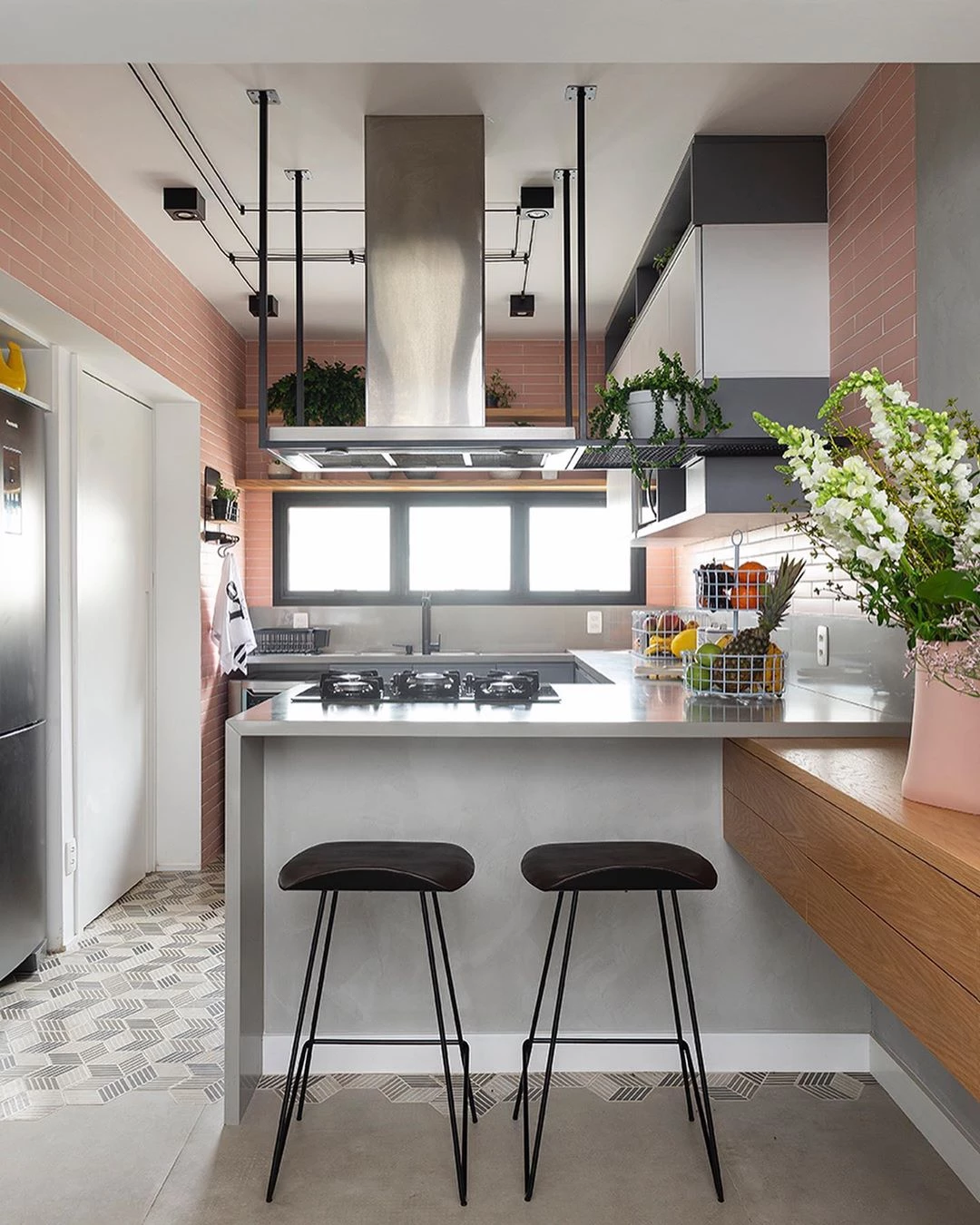 Cozinha com parede preta e armários em rosa