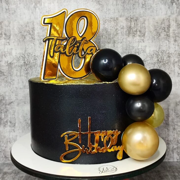 O bolo de férias é decorado com bolas douradas, brilhos dourados e  macaroons pretos bolo de aniversário masculino 60 anos fechar